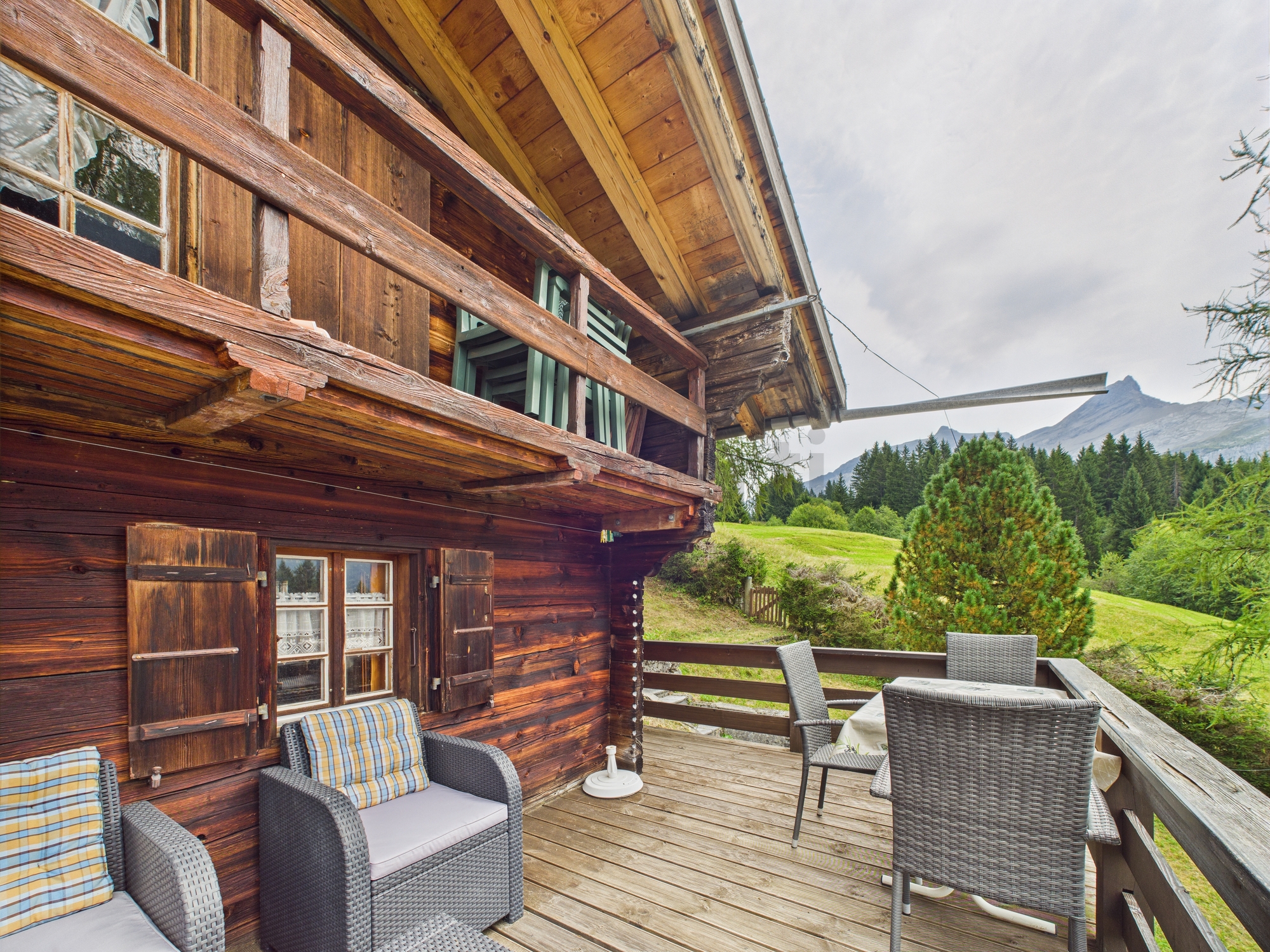 Balkon einer rustikalen Holzchalet-Fassade mit Bergblick