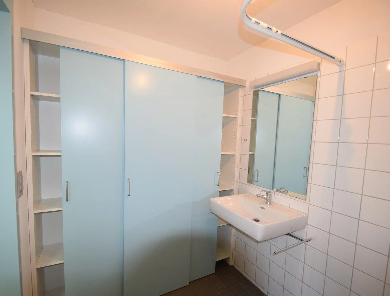 Helles Badezimmer mit Einbauschrank und Waschtisch