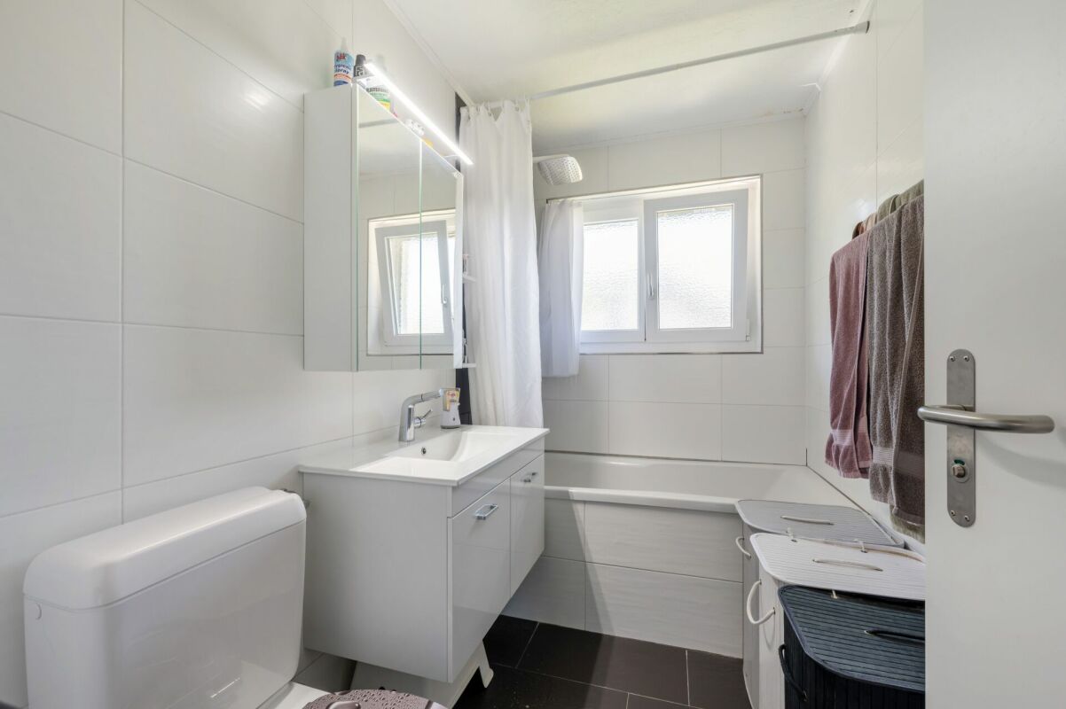Helles, modernes Badezimmer mit Badewanne und Waschtisch
