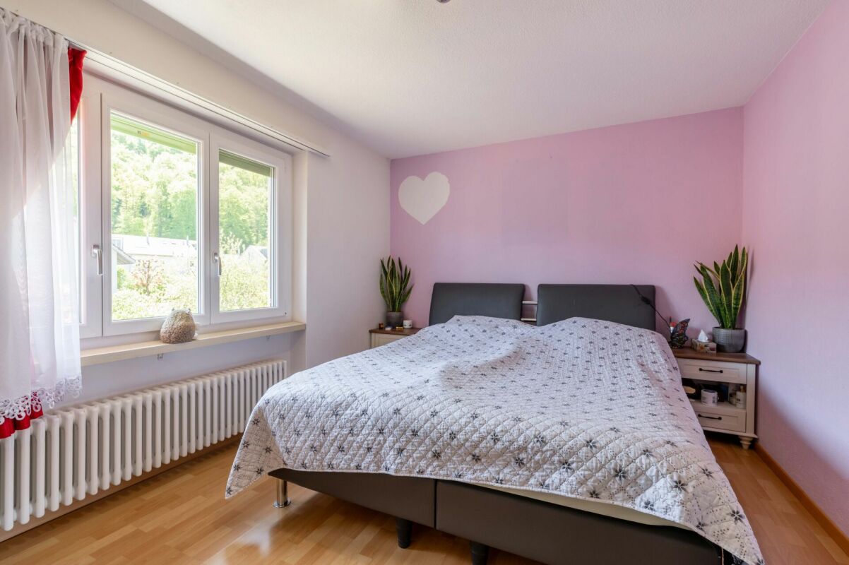 Helles Schlafzimmer mit Doppelbett und Fenster