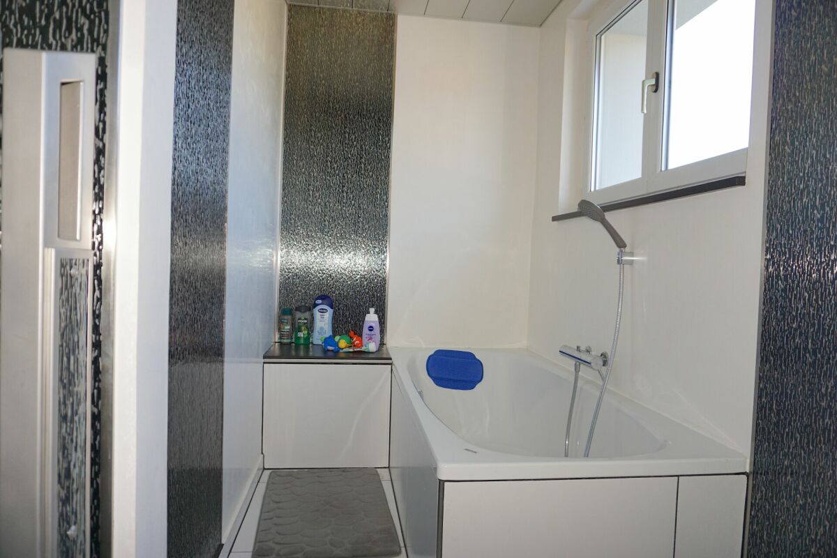 Modernes Badezimmer mit Badewanne und Duschbereich