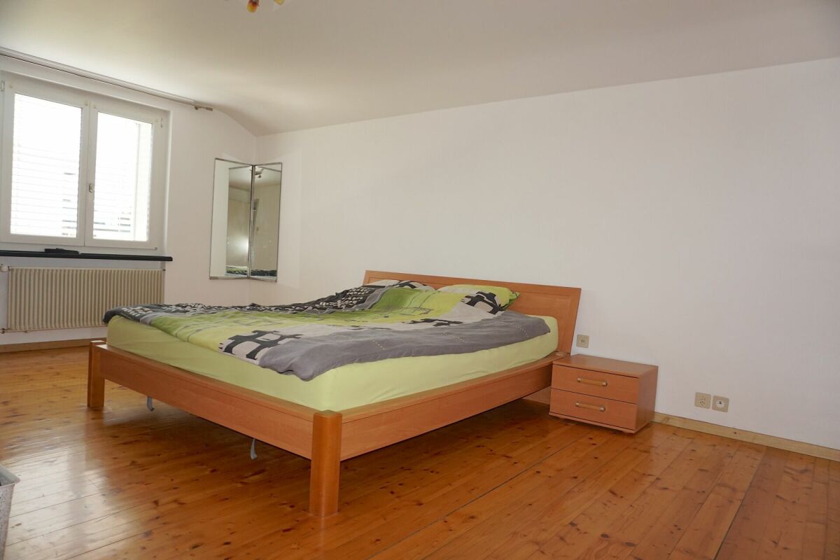Schlafzimmer mit Holzboden und Doppelbett