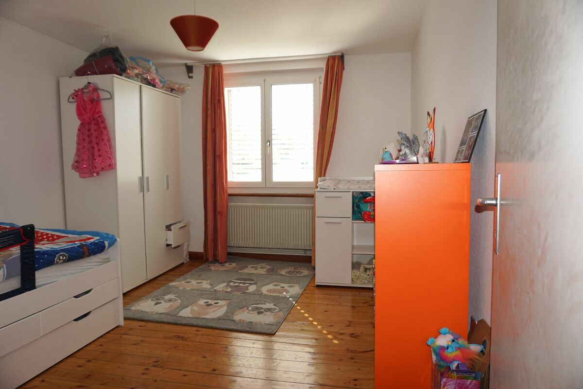 Kinderzimmer mit Schrank, Bett und Fenster