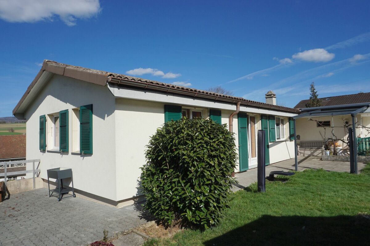 Einfamilienhaus mit Garten und grünen Fensterläden