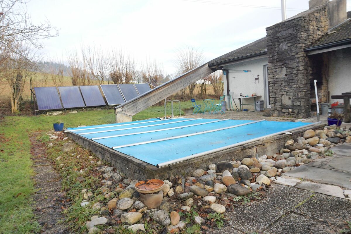Außenbereich mit Poolabdeckung und Solarpanelen