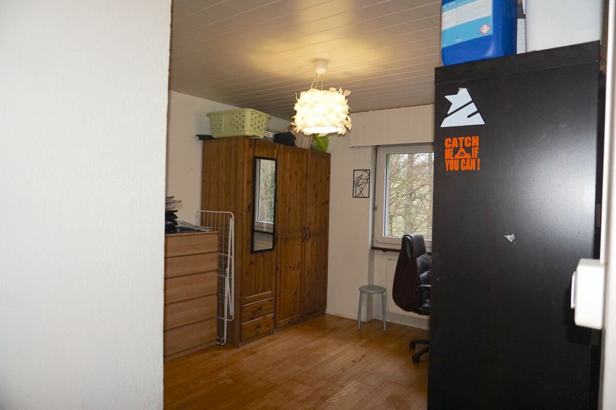 Kleines Arbeits- oder Schlafzimmer mit Holzschrank