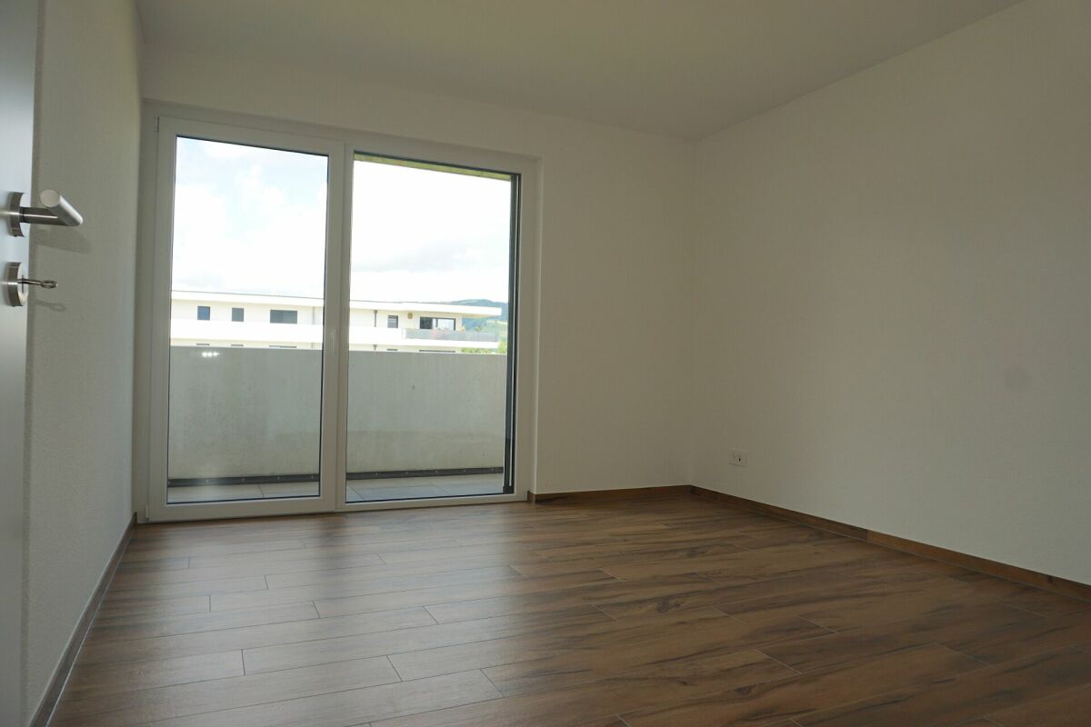Leerer Wohnraum mit Balkon und Blick nach draußen