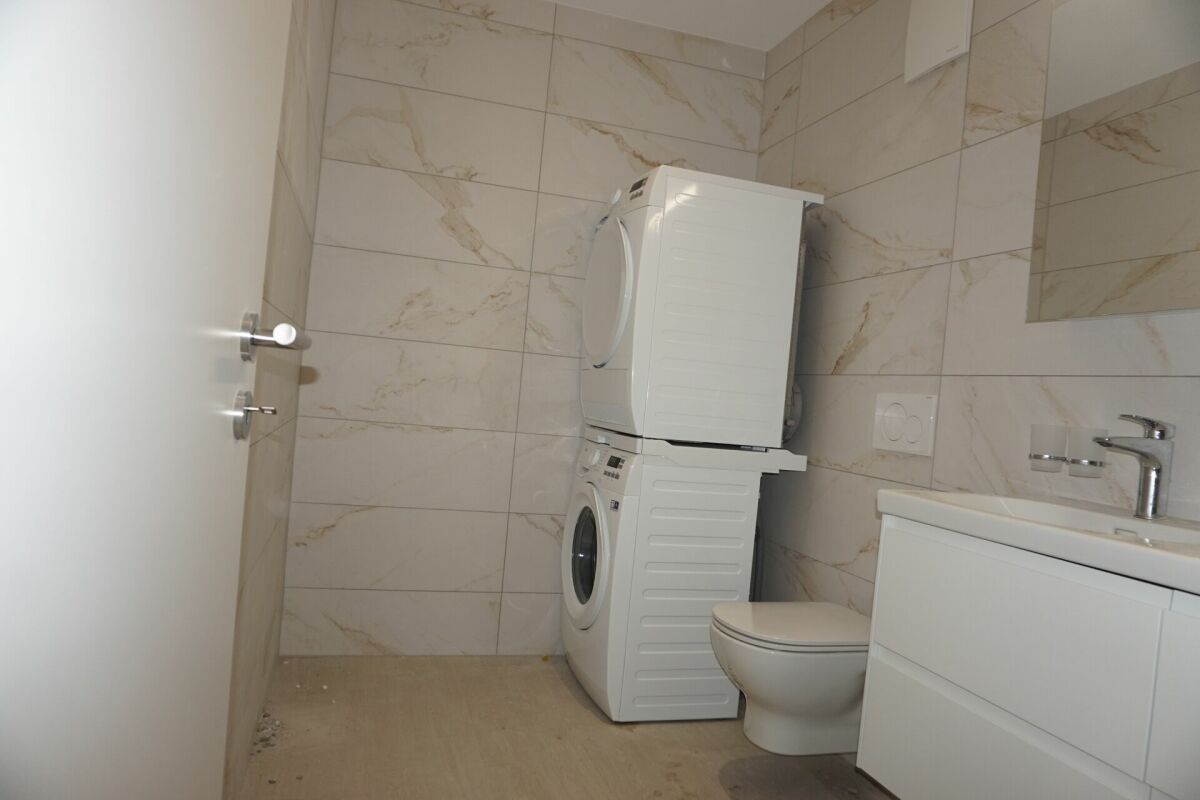 Modernes Badezimmer mit Waschmaschine und WC