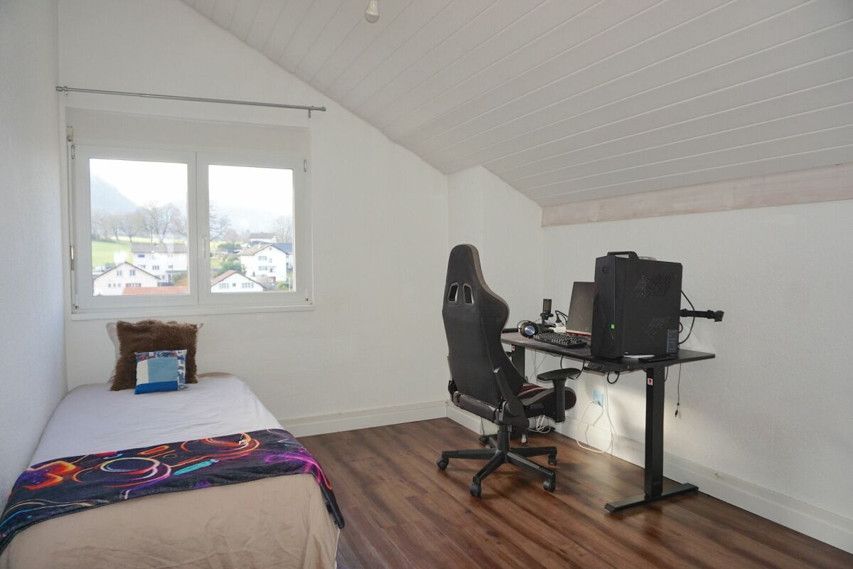 Dachgeschosszimmer mit Bett und Arbeitsplatz