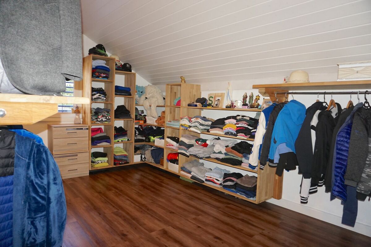 Ankleidezimmer mit offenen Regalen und hängender Kleidung