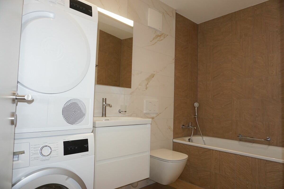 Modernes Badezimmer mit Waschtisch, Trockner und Badewanne