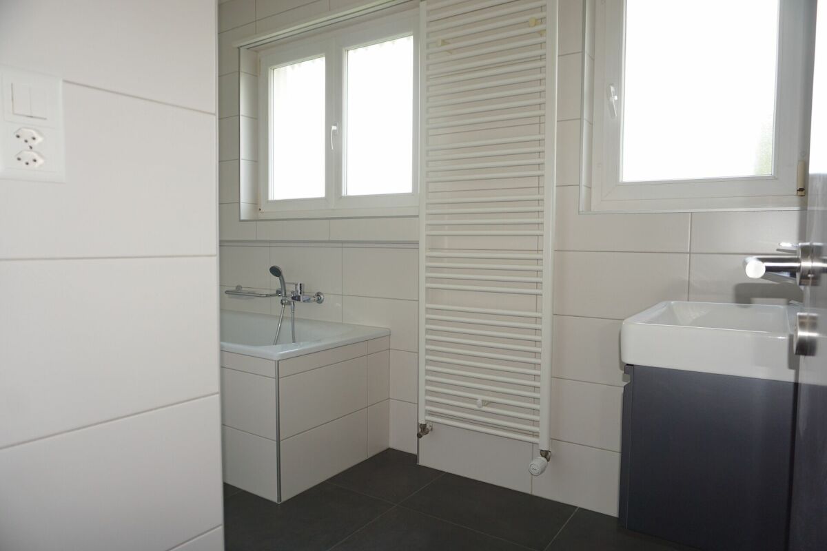 Helles Badezimmer mit Wanne und Fenster