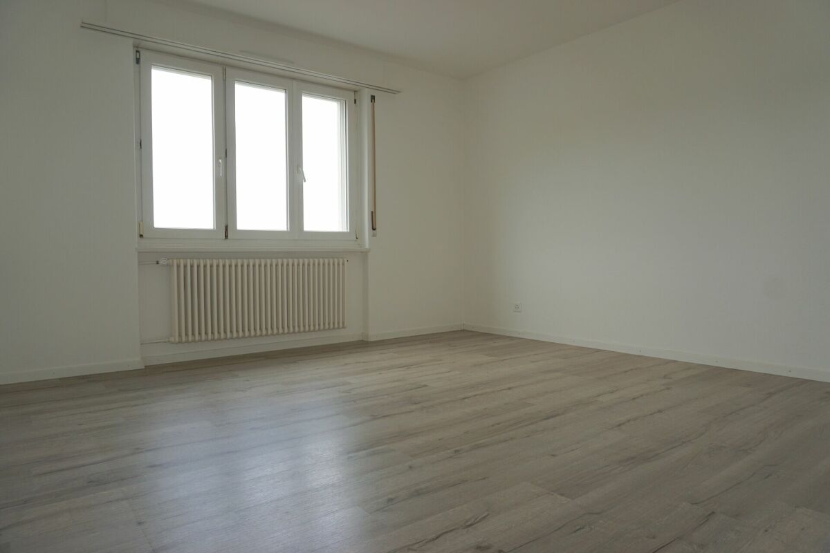 Leerer heller Raum mit Fenster und Heizkörper