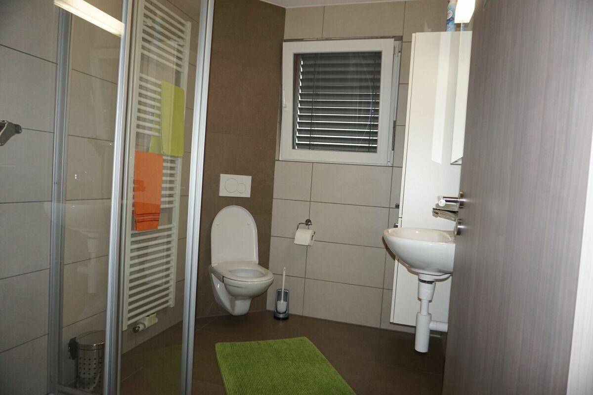 Badezimmer mit Dusche, WC und Waschbecken