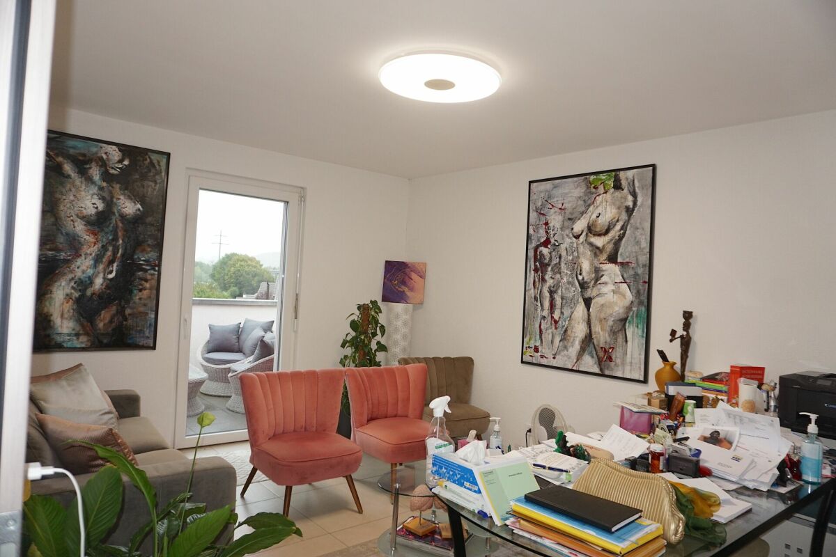 Wohnzimmer mit Balkonzugang und Kunstwerken