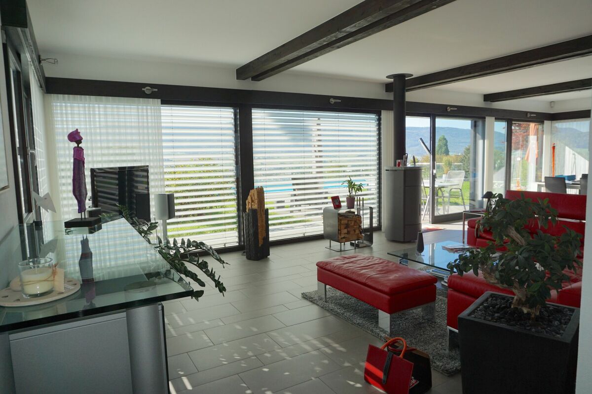 Modernes Wohnzimmer mit großflächigen Fensterfronten
