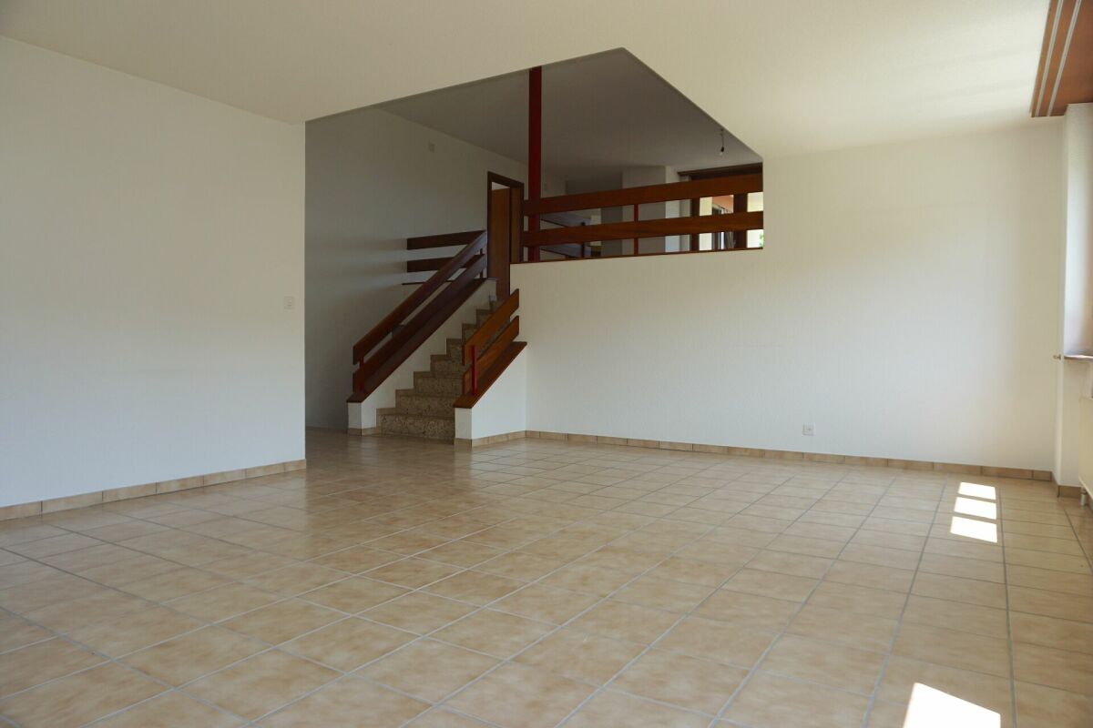 Leerer Wohnraum mit Treppe und Empore