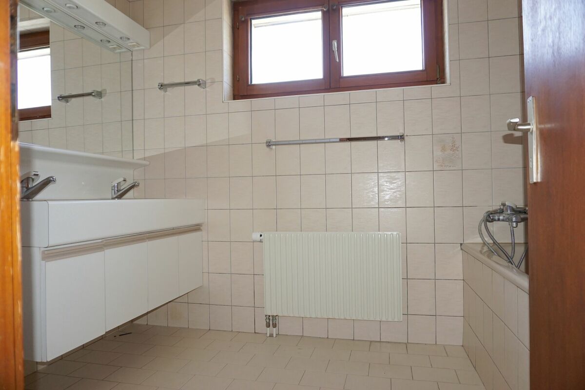 Badezimmer mit Fliesen, Fenster und Badewanne