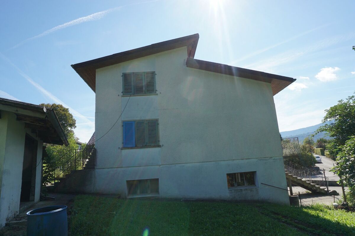 Wohnhaus mit geneigtem Dach und Gartenansicht