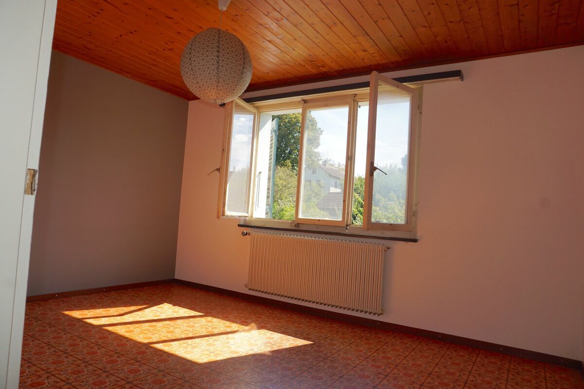 Leeres Zimmer mit Holzdecke und geöffnetem Fenster