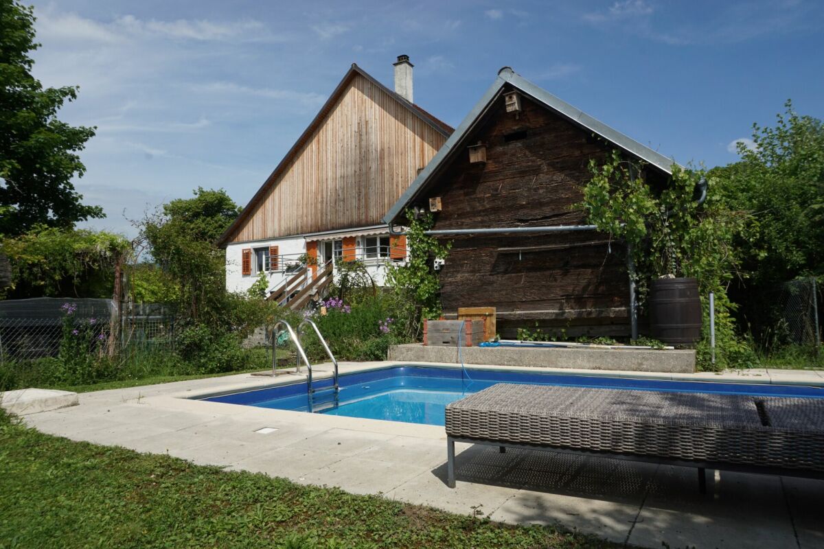 Garten mit Pool vor zwei Gebäudeteilen