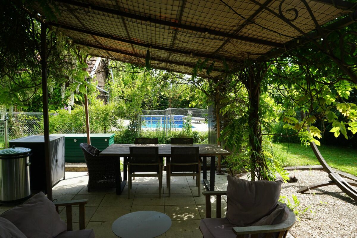 Überdachte Terrasse mit Garten und Poolblick