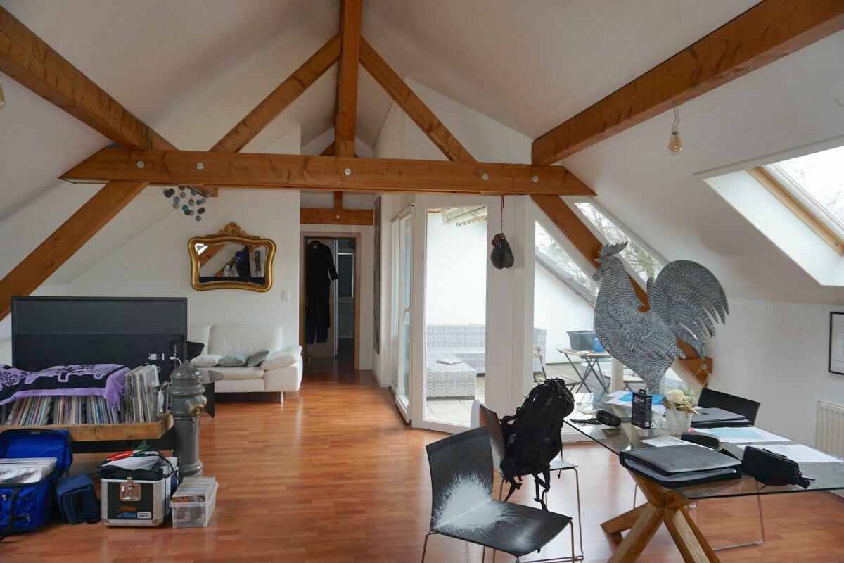 Dachgeschoss-Wohnraum mit sichtbaren Holzbalken