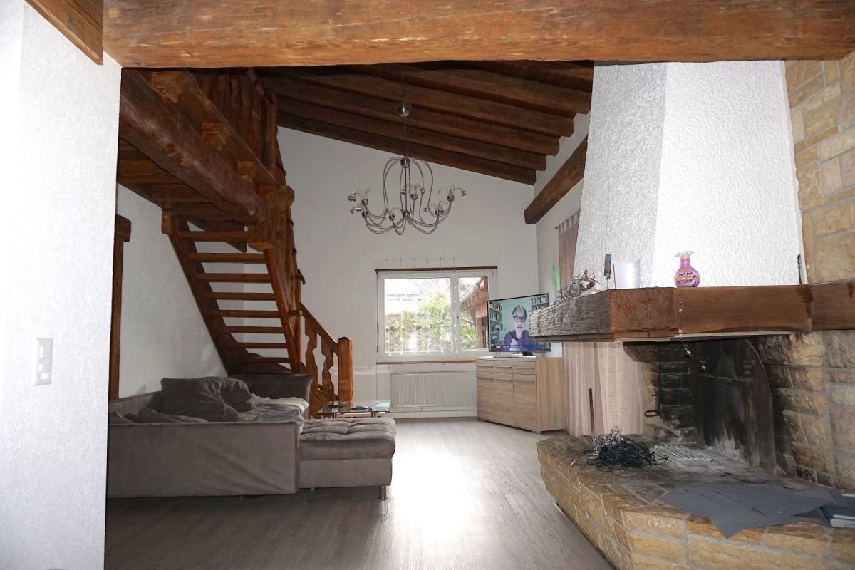 Wohnzimmer mit Holzbalkendecke und Kamin