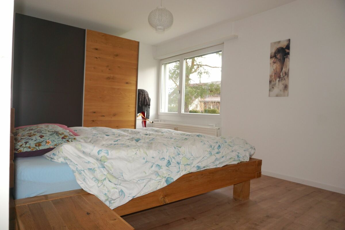 Helles Schlafzimmer mit Holzbett und Kleiderschrank