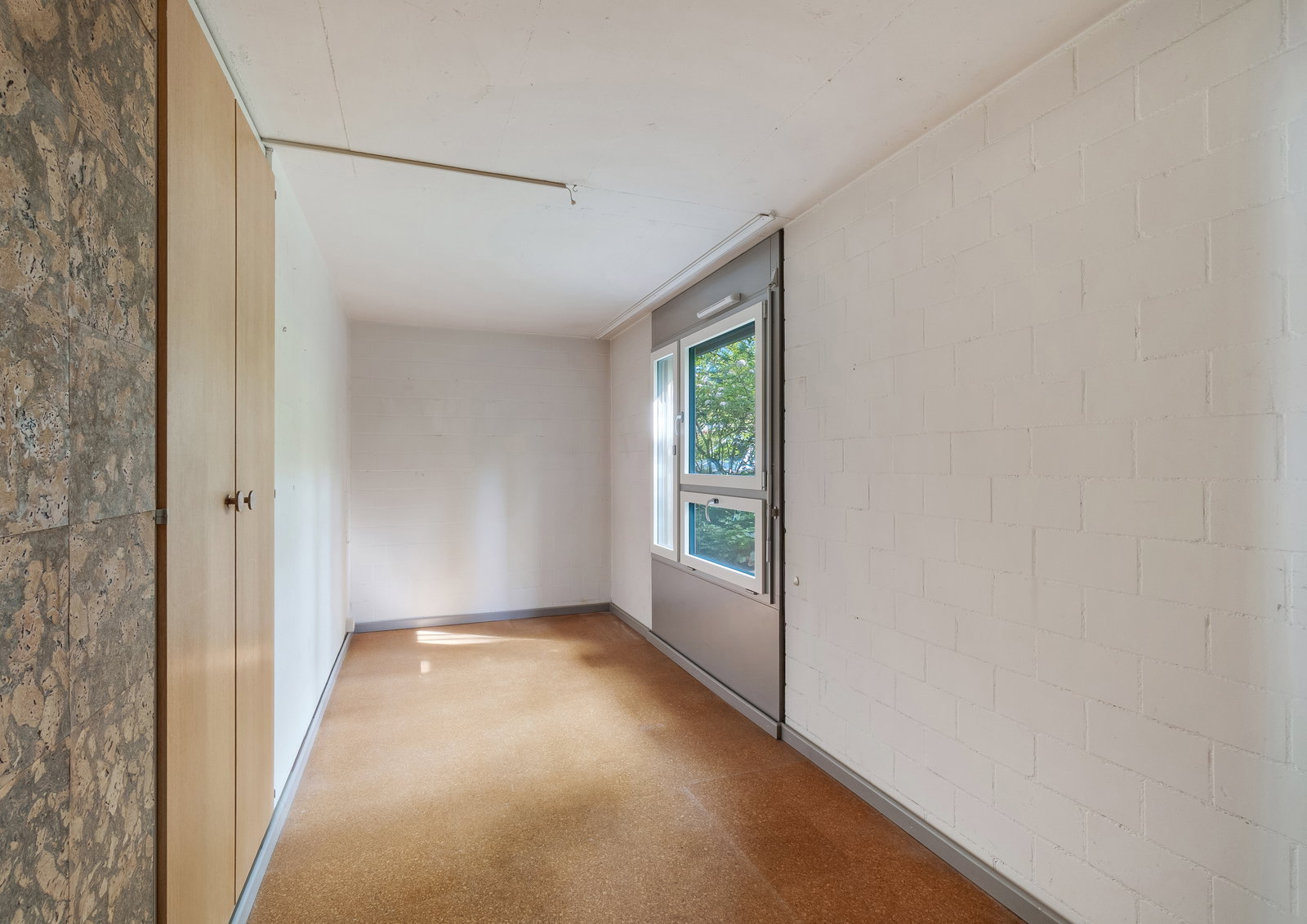 Schmaler Innenraum mit Fenster und Einbauschrank