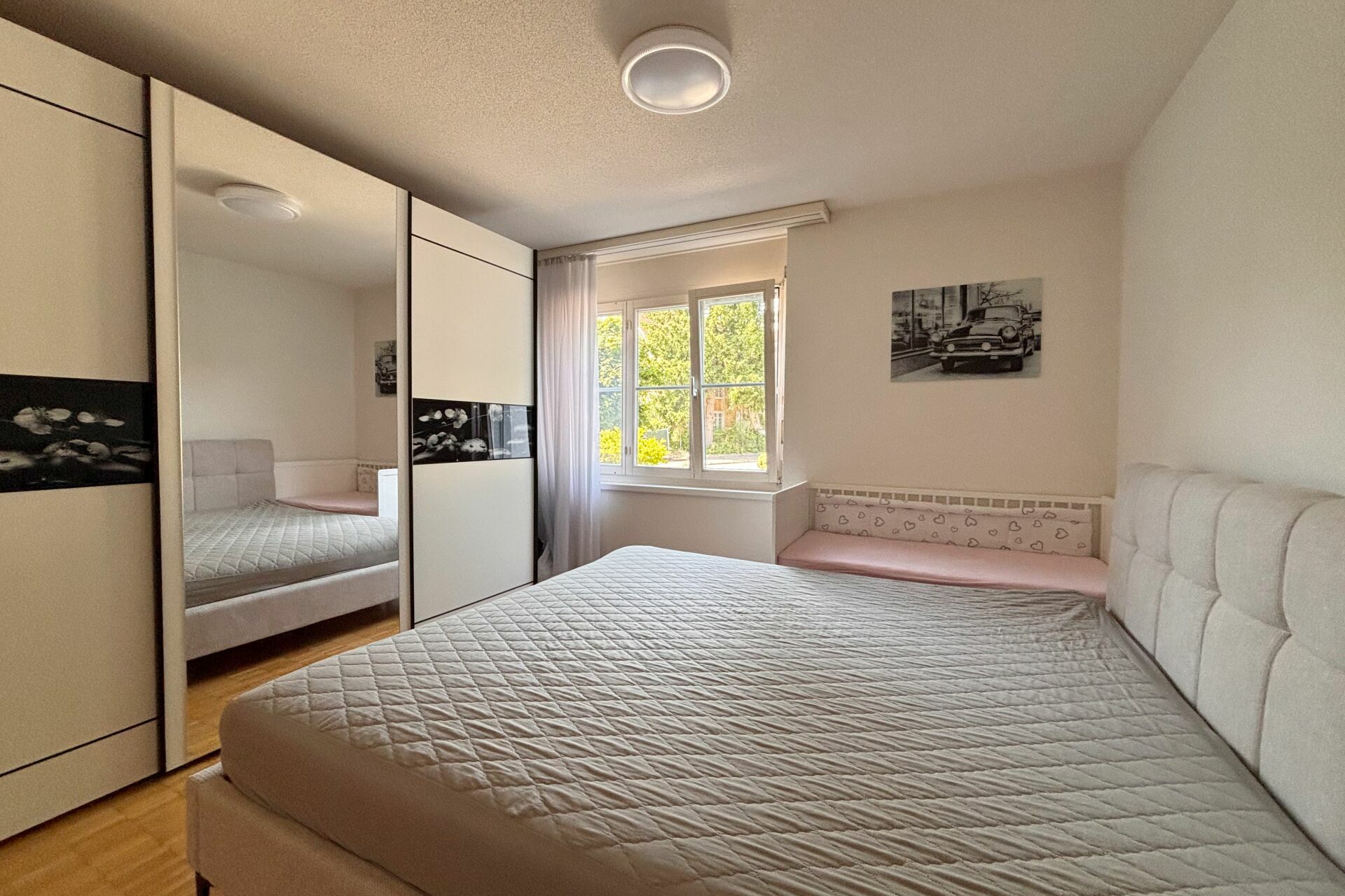 Helles Schlafzimmer mit Einbauschrank und Doppelbett