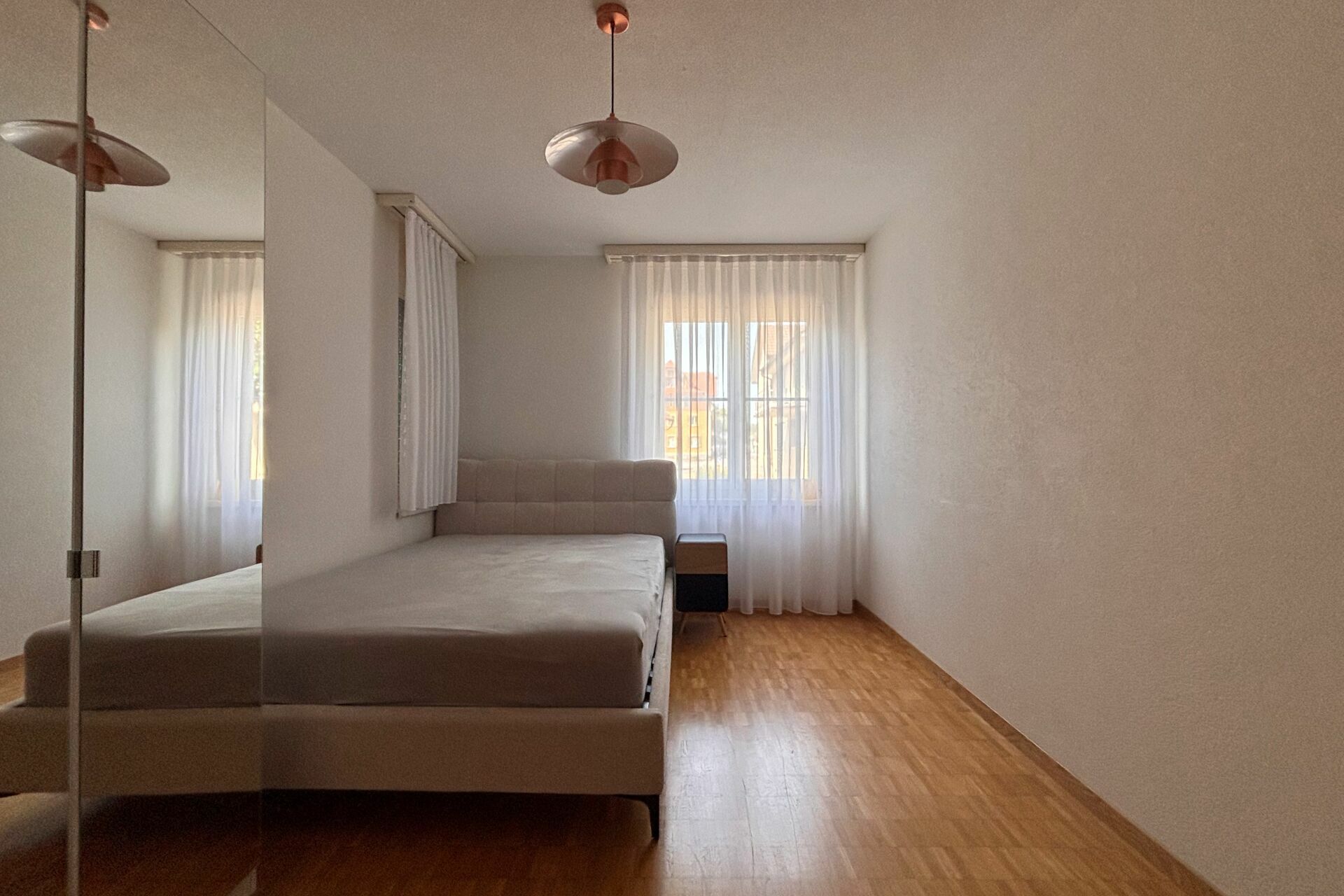 Helles Schlafzimmer mit Doppelbett und Fenster