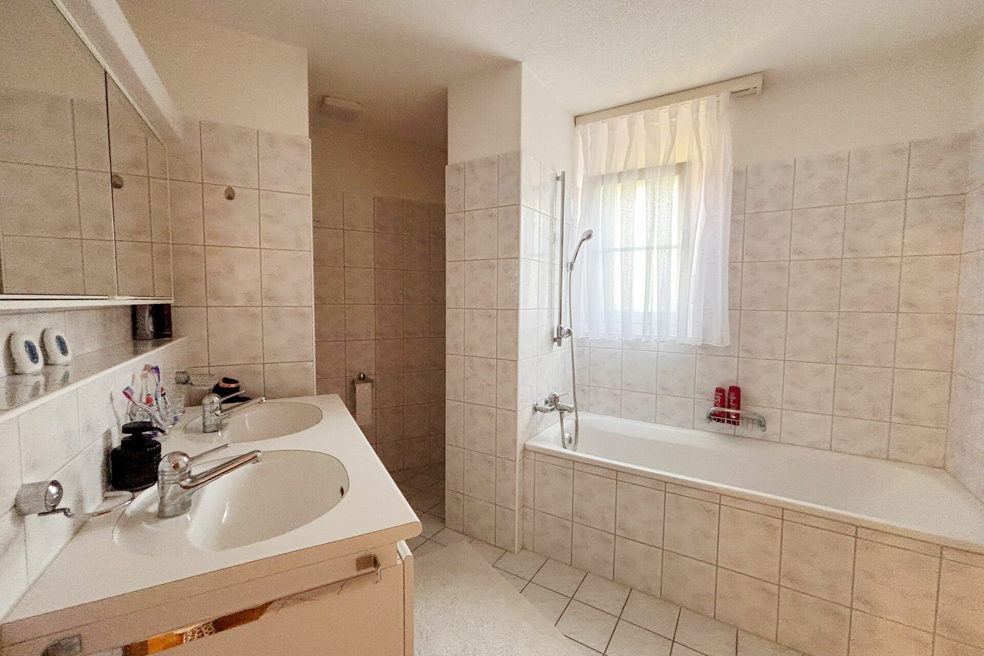 Helles Badezimmer mit Badewanne und Doppelwaschtisch