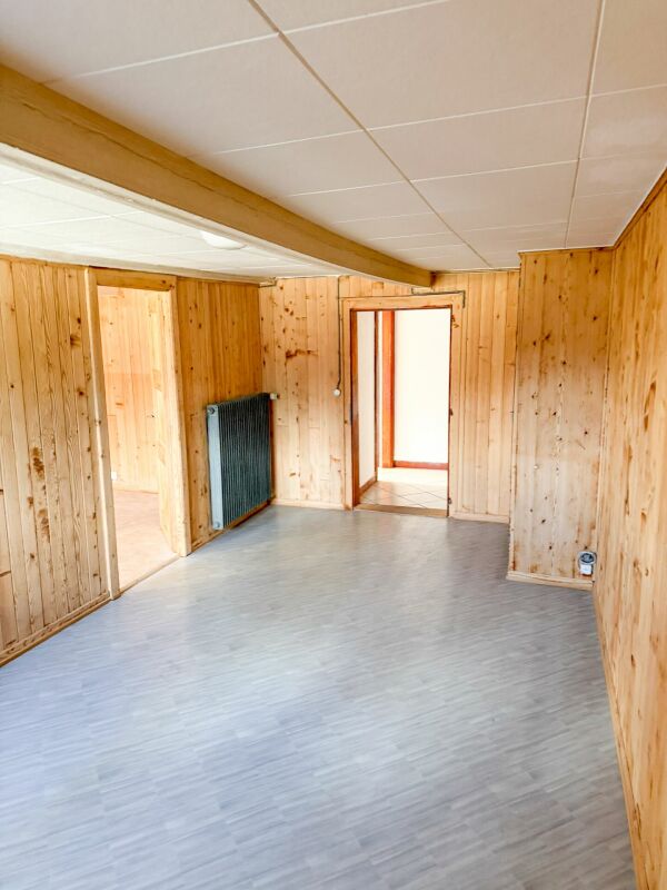 Holzvertäfelter Raum mit grauem Boden