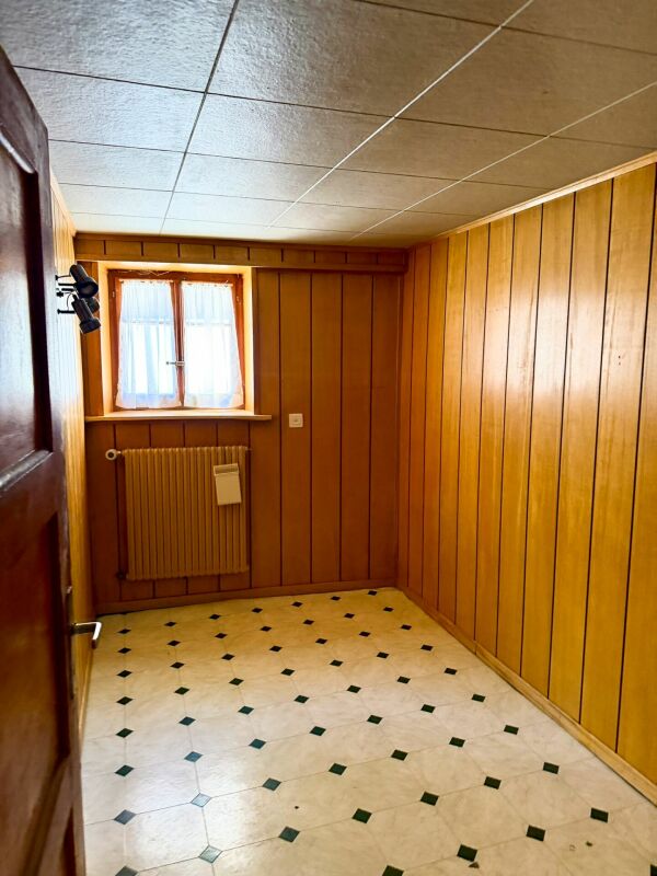 Kleiner holzvertäfelter Raum mit Fliesenboden