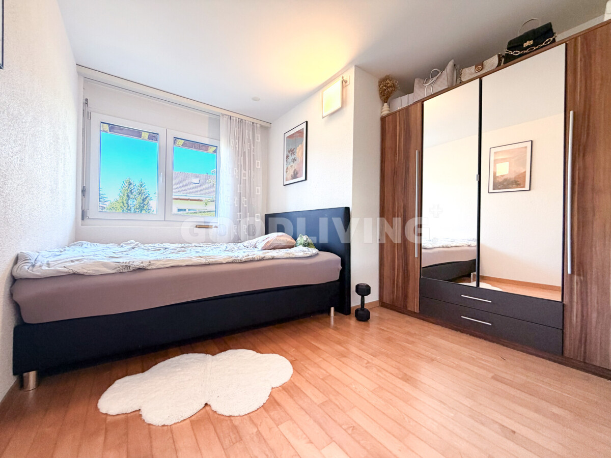 Helles Schlafzimmer mit Bett und Kleiderschrank