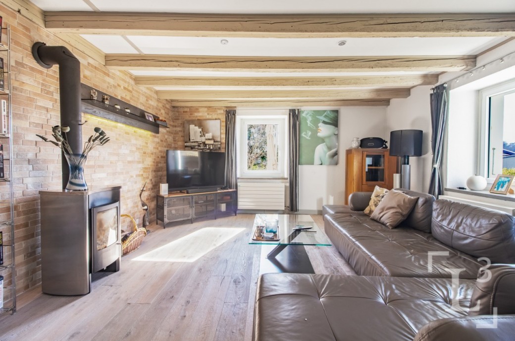 Gemütliches Wohnzimmer mit Holzdecke und Kaminofen