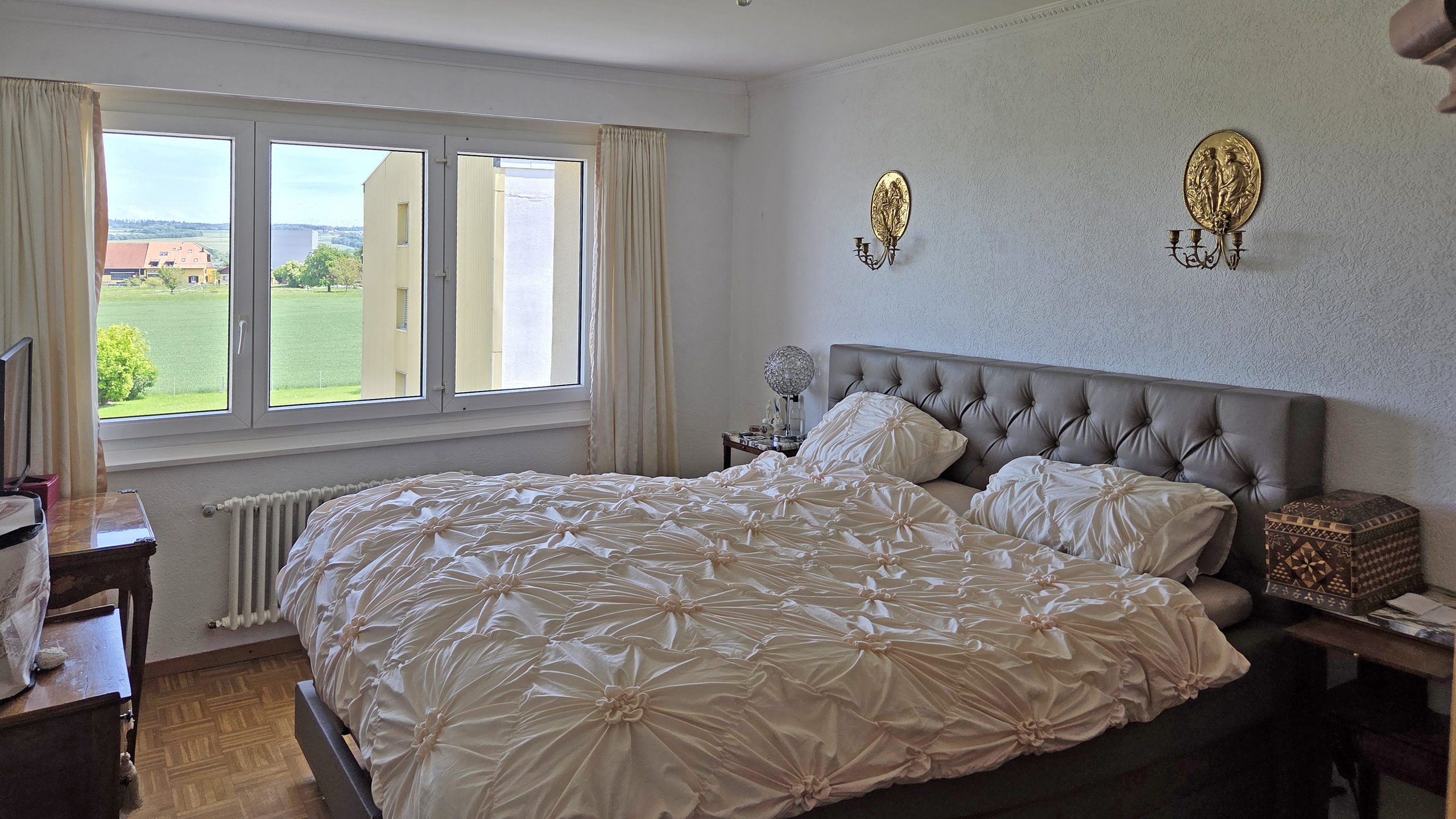 Schlafzimmer mit großem Fenster und Doppelbett