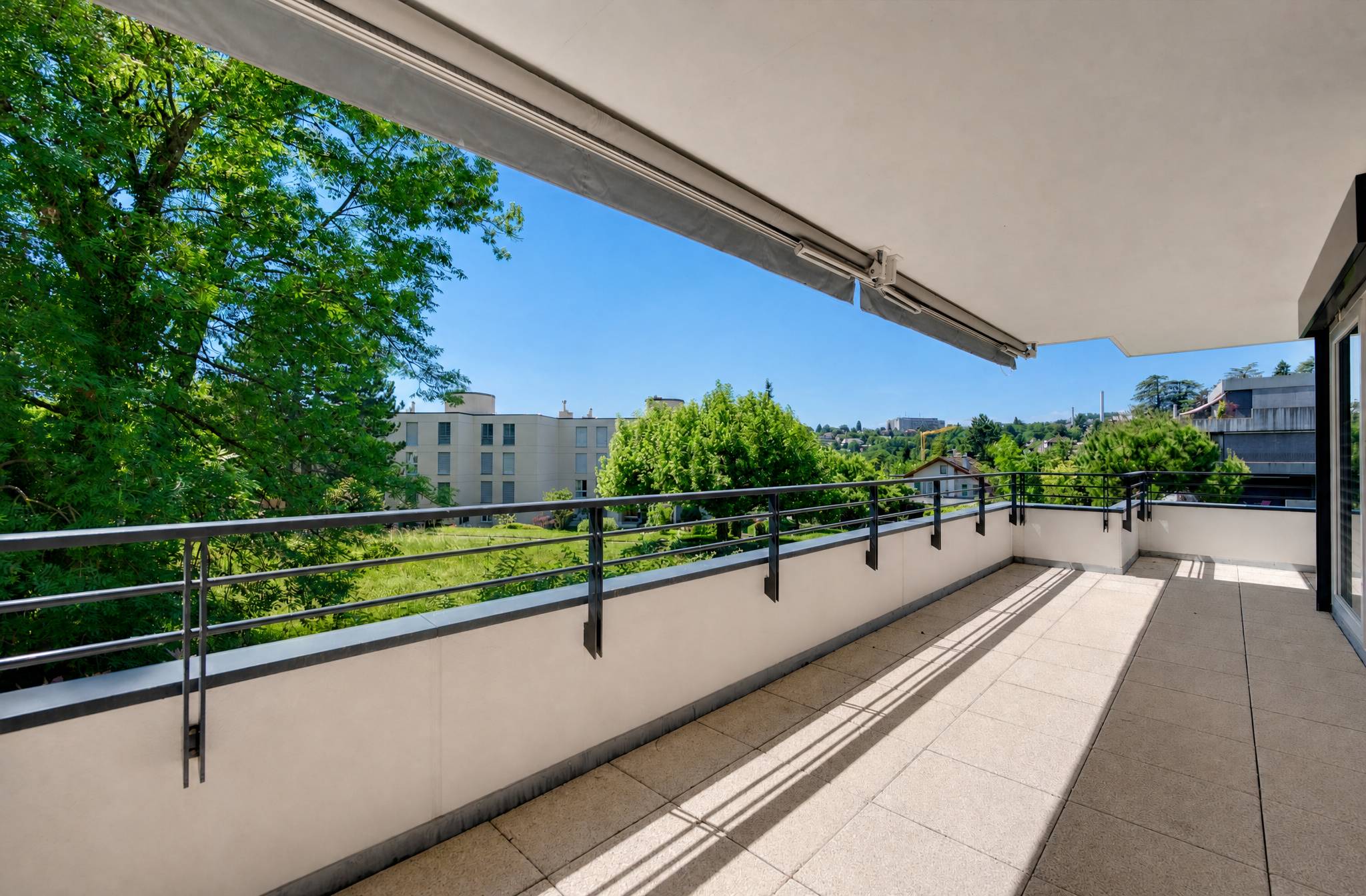 Großer überdachter Balkon mit Blick ins Grüne