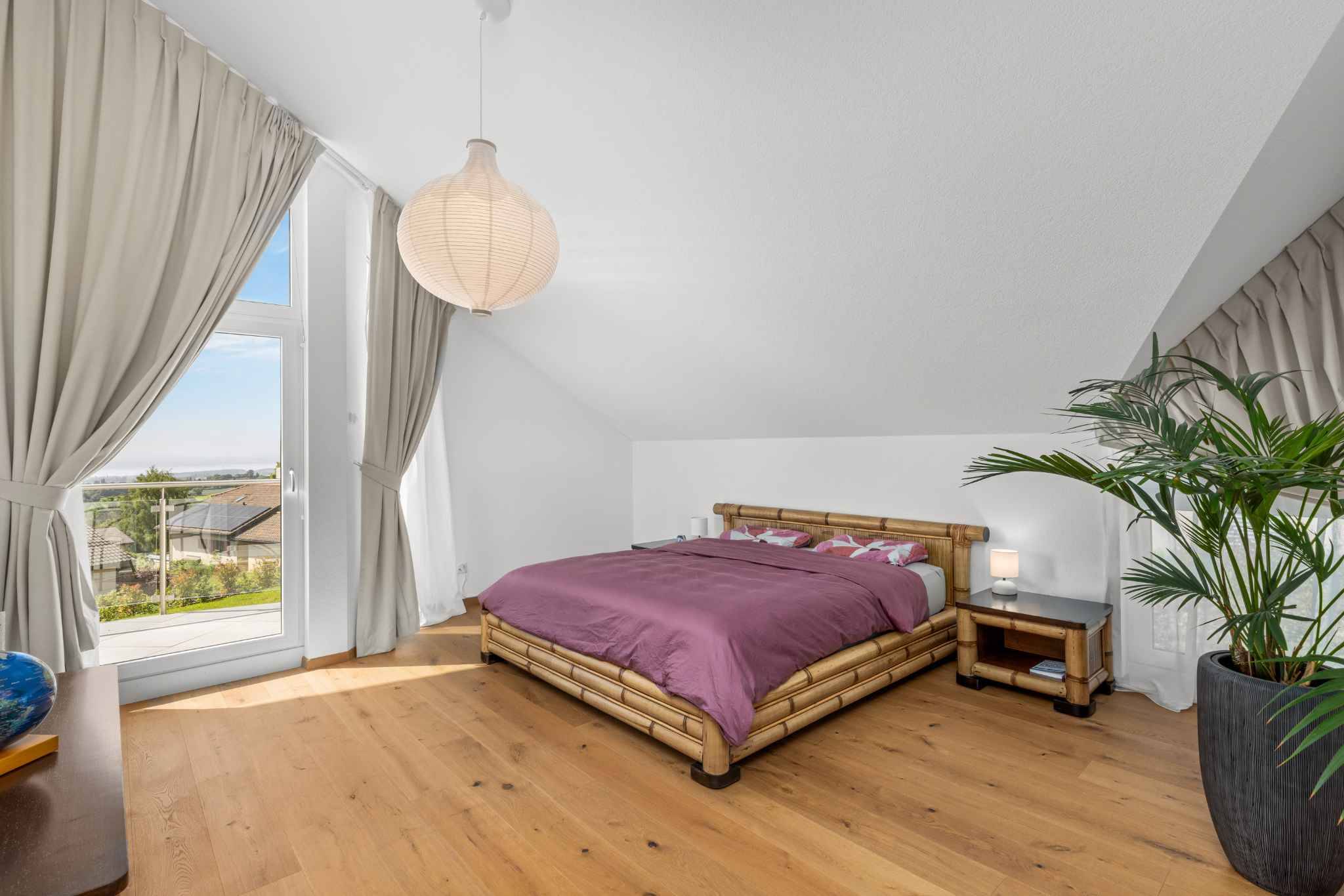 Helles Schlafzimmer mit Dachschräge und Naturholz-Bett