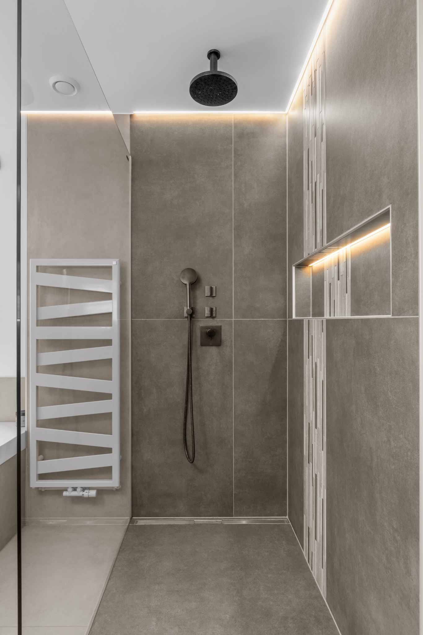 Moderne Dusche mit grauen Fliesen und LED-Beleuchtung