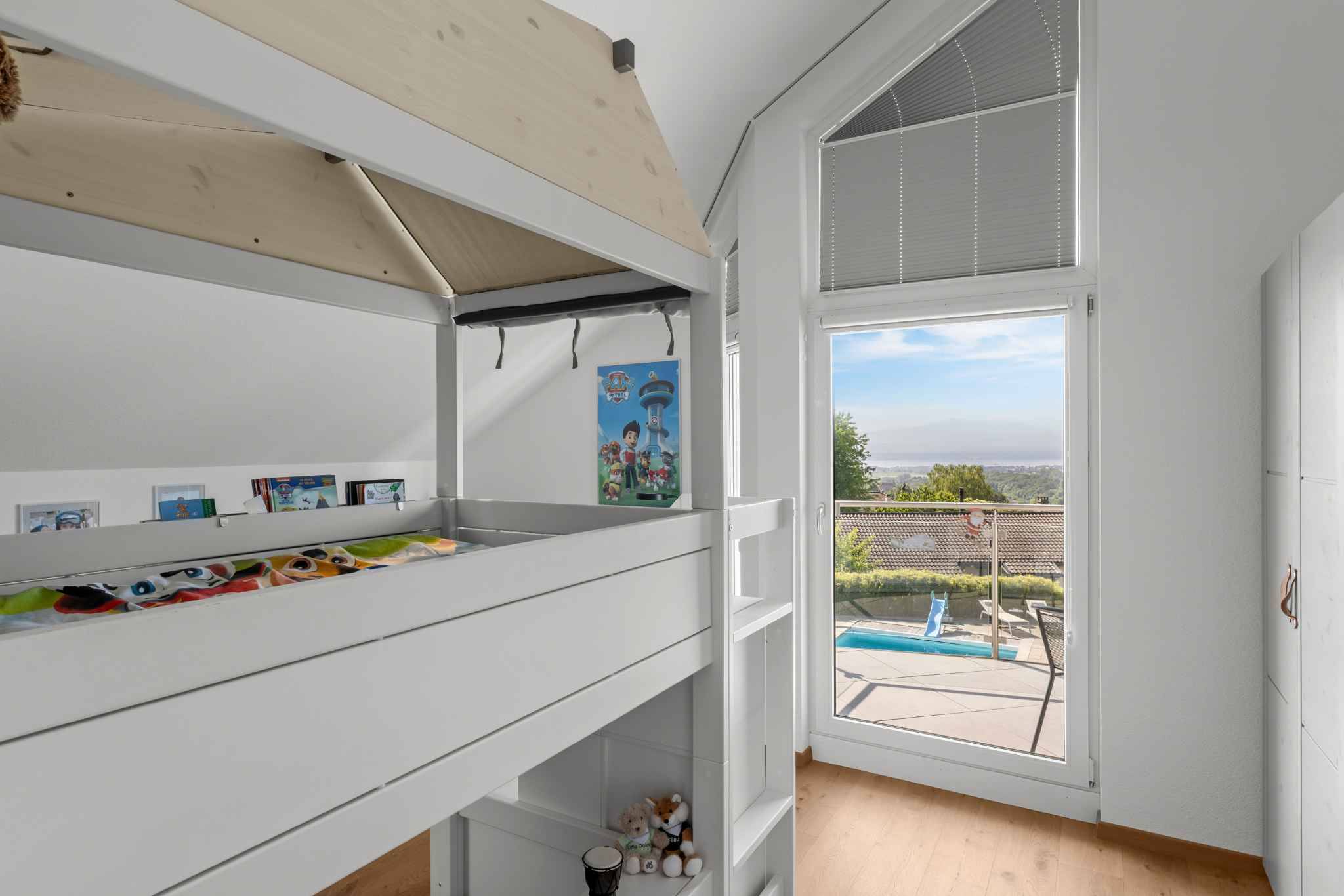 Helles Kinderzimmer mit Hochbett und Balkonblick