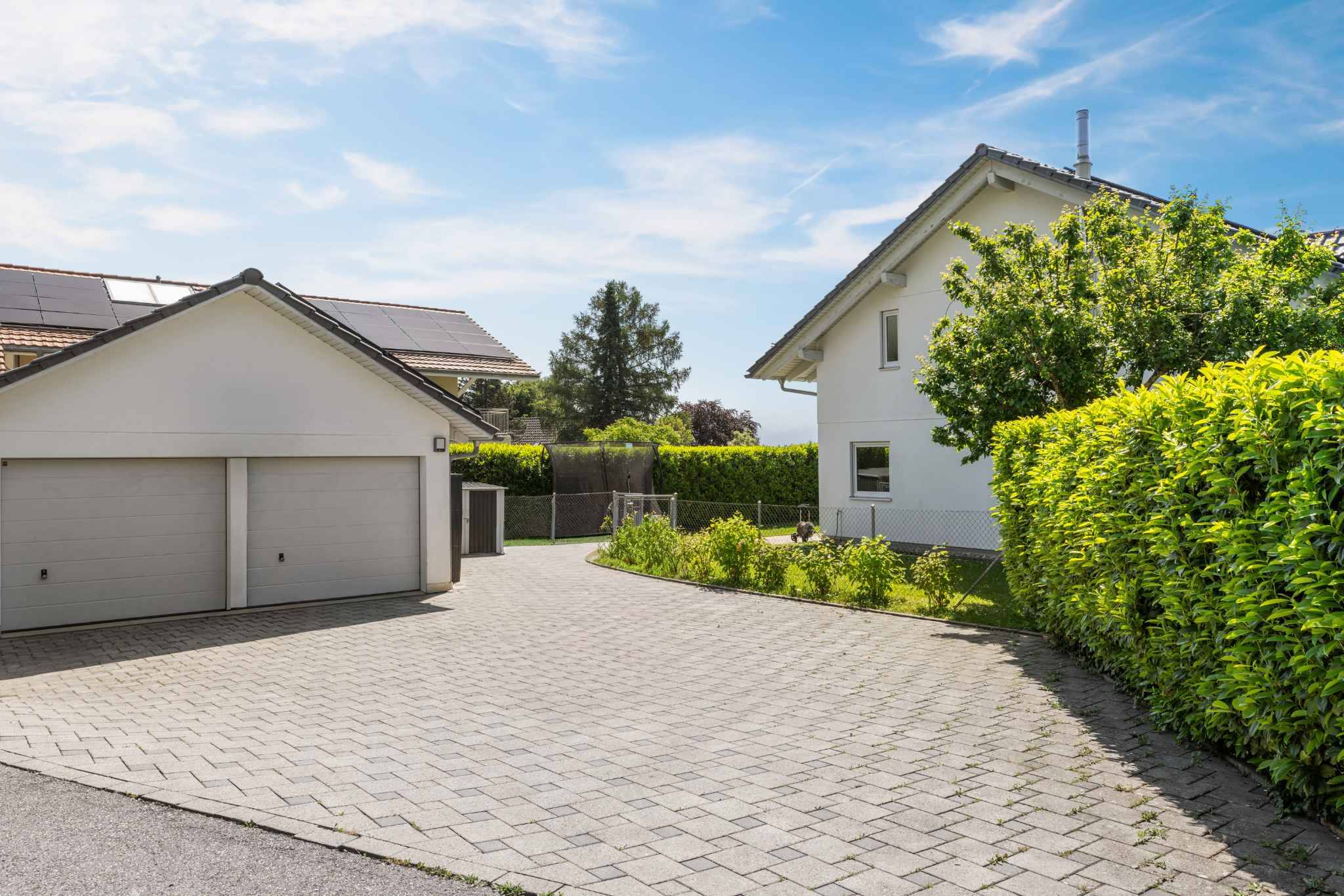 Helle Einfahrt mit Doppelgarage und Garten