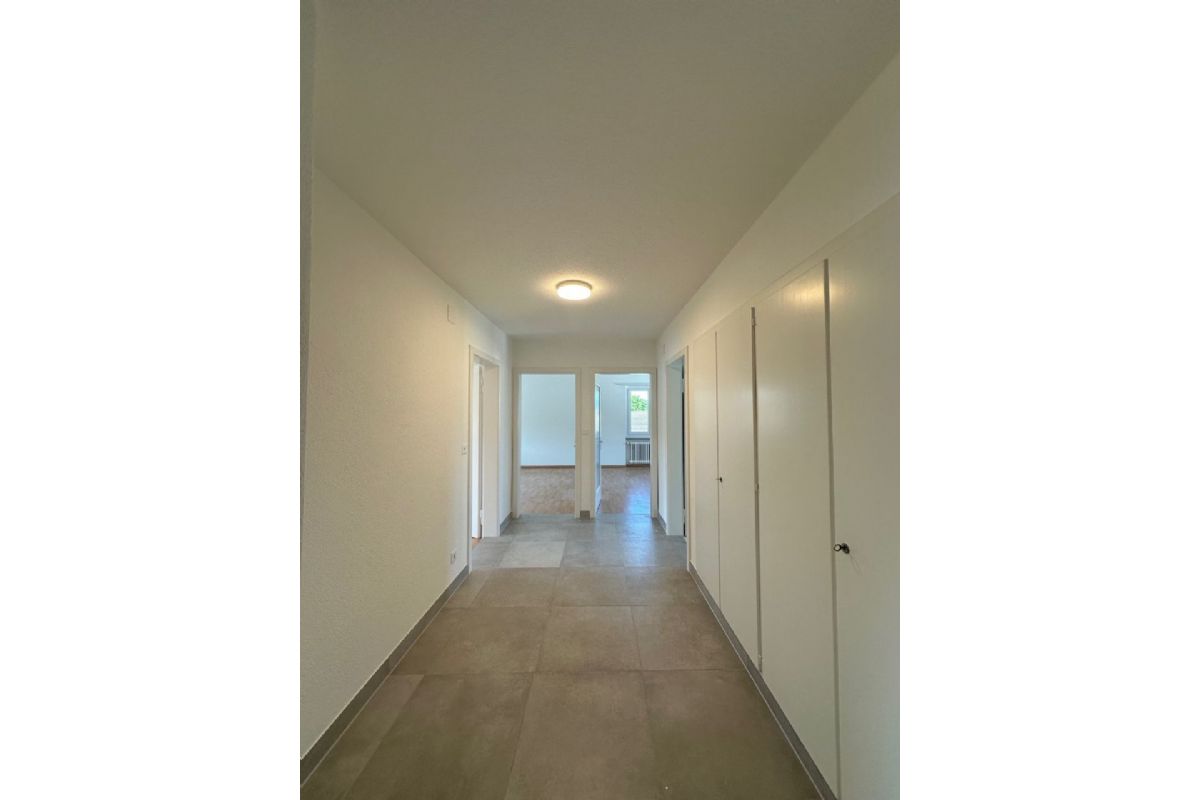 Heller Flur mit Türen und Blick in einen Wohnraum
