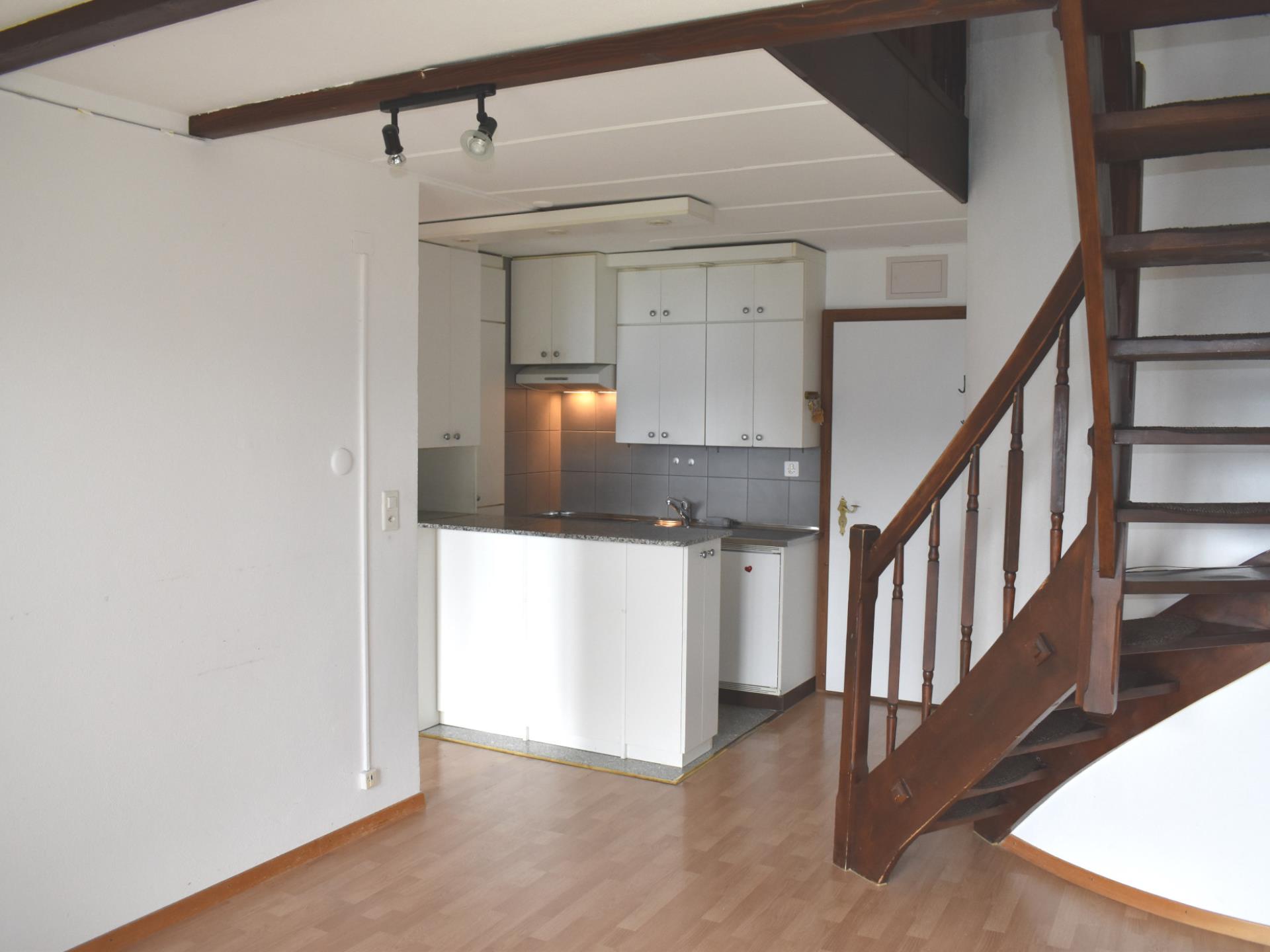 Wohnraum mit Küchenzeile und Treppe