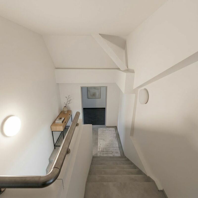 Treppenhaus mit Blick in einen angrenzenden Raum