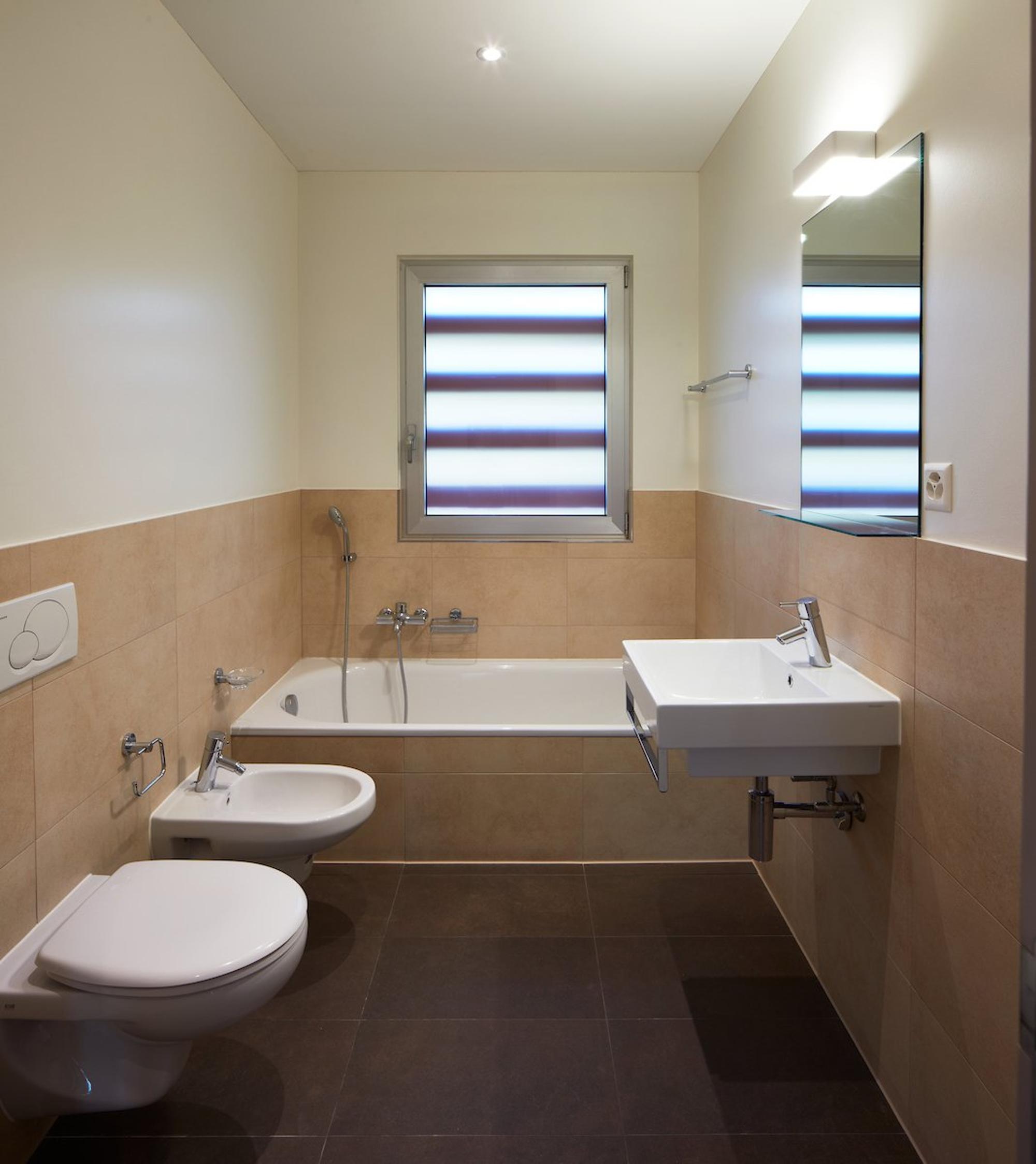 Helles Badezimmer mit Badewanne, WC und Waschbecken