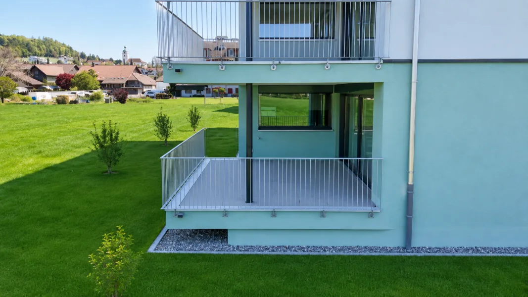 Außenansicht mit Balkon und Grünfläche