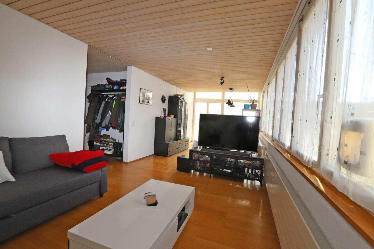 Wohnzimmer mit Holzdecke und großer Fensterfront