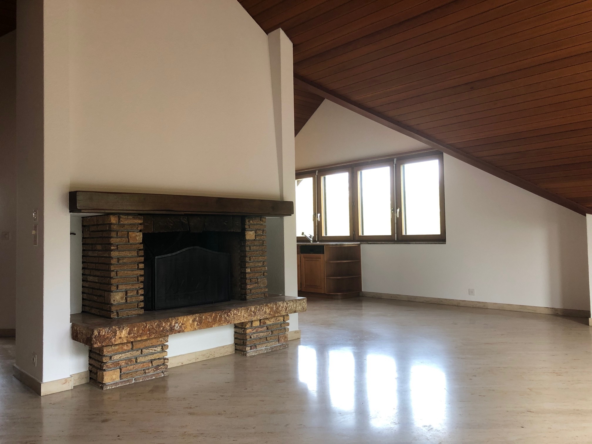 Wohnraum mit Kamin und Dachschräge